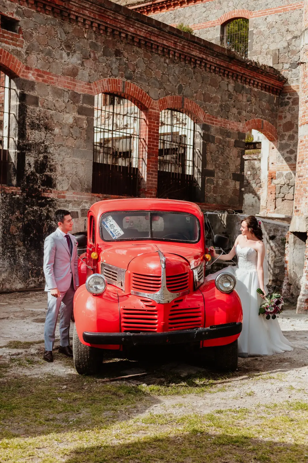 Cecilia y Josué junto al auto clásico rojo