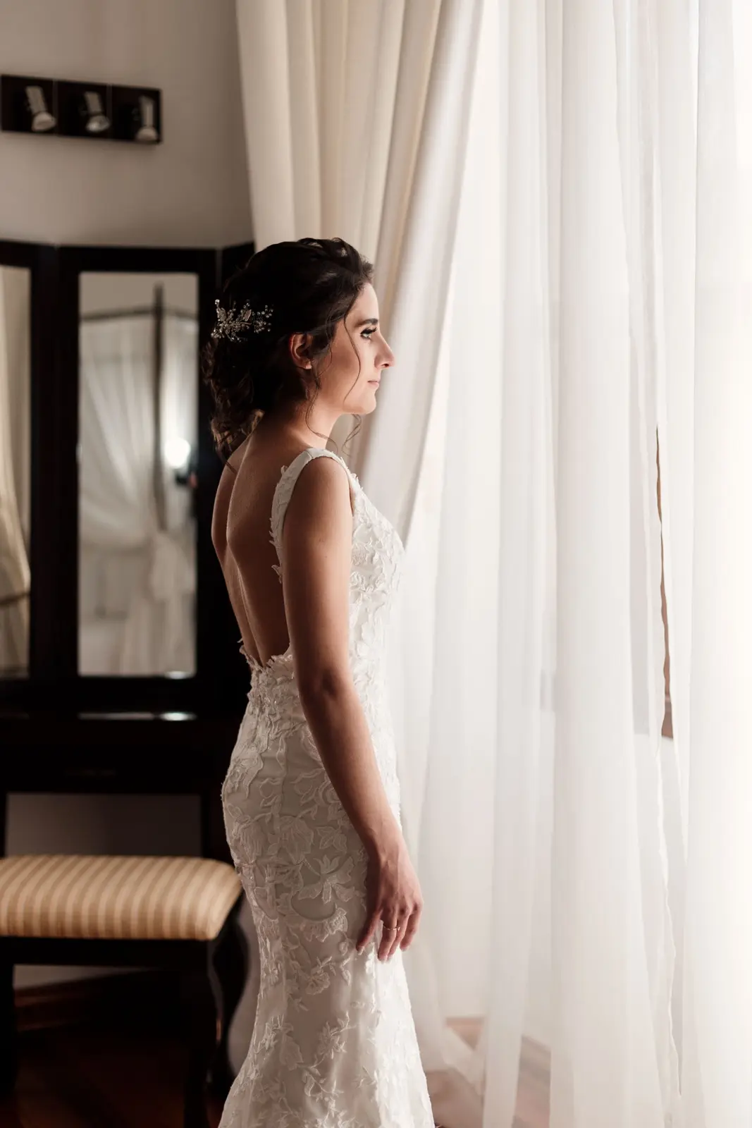 Claudia vestida de novia junto a una ventana