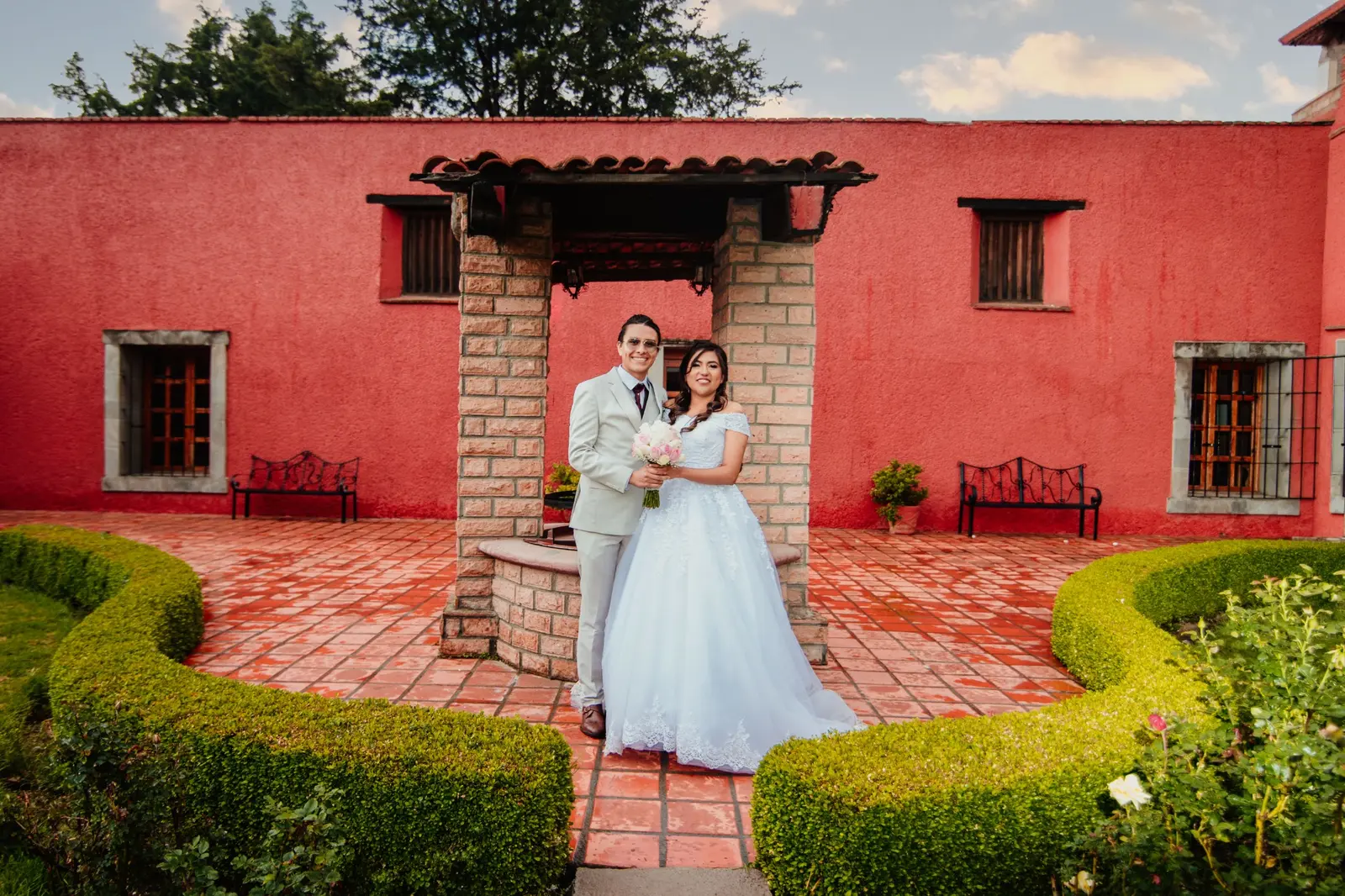 Luis y Marlen frente a la arquitectura roja de la hacienda