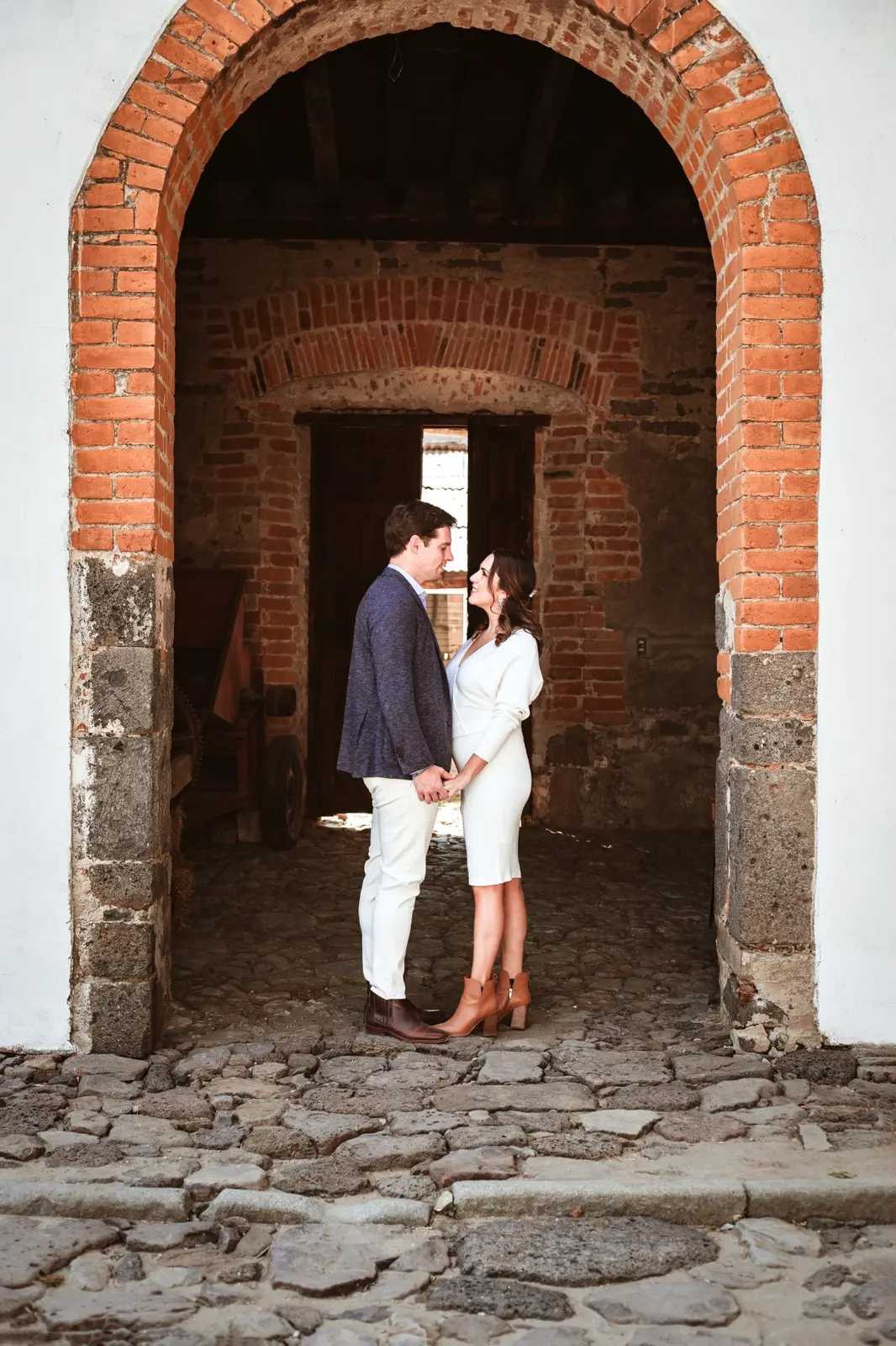 La pareja tomada de las manos bajo un arco