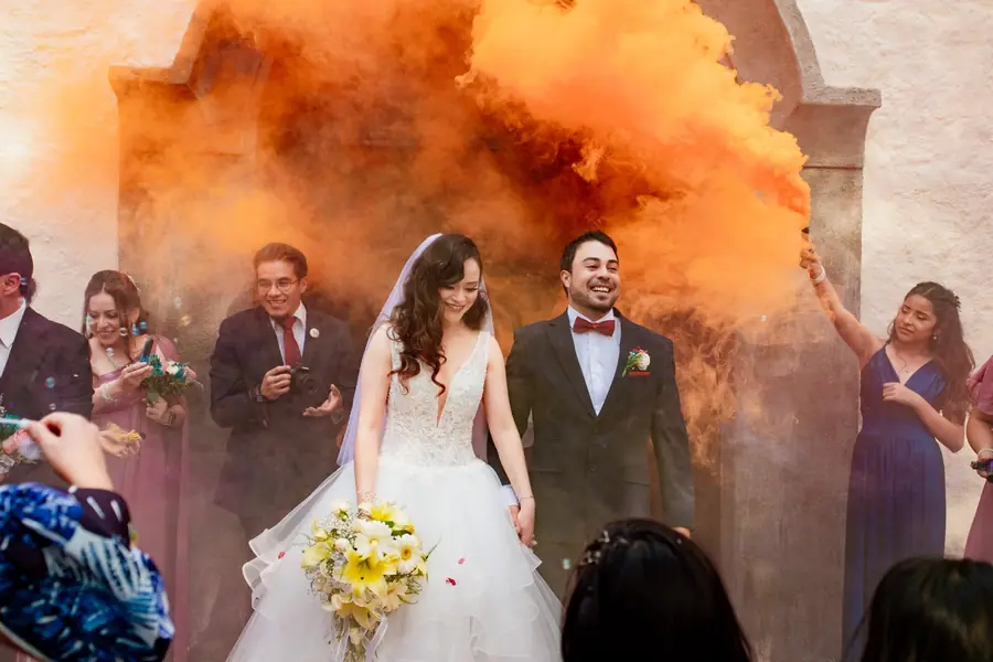 Novios celebrando entre humo de color